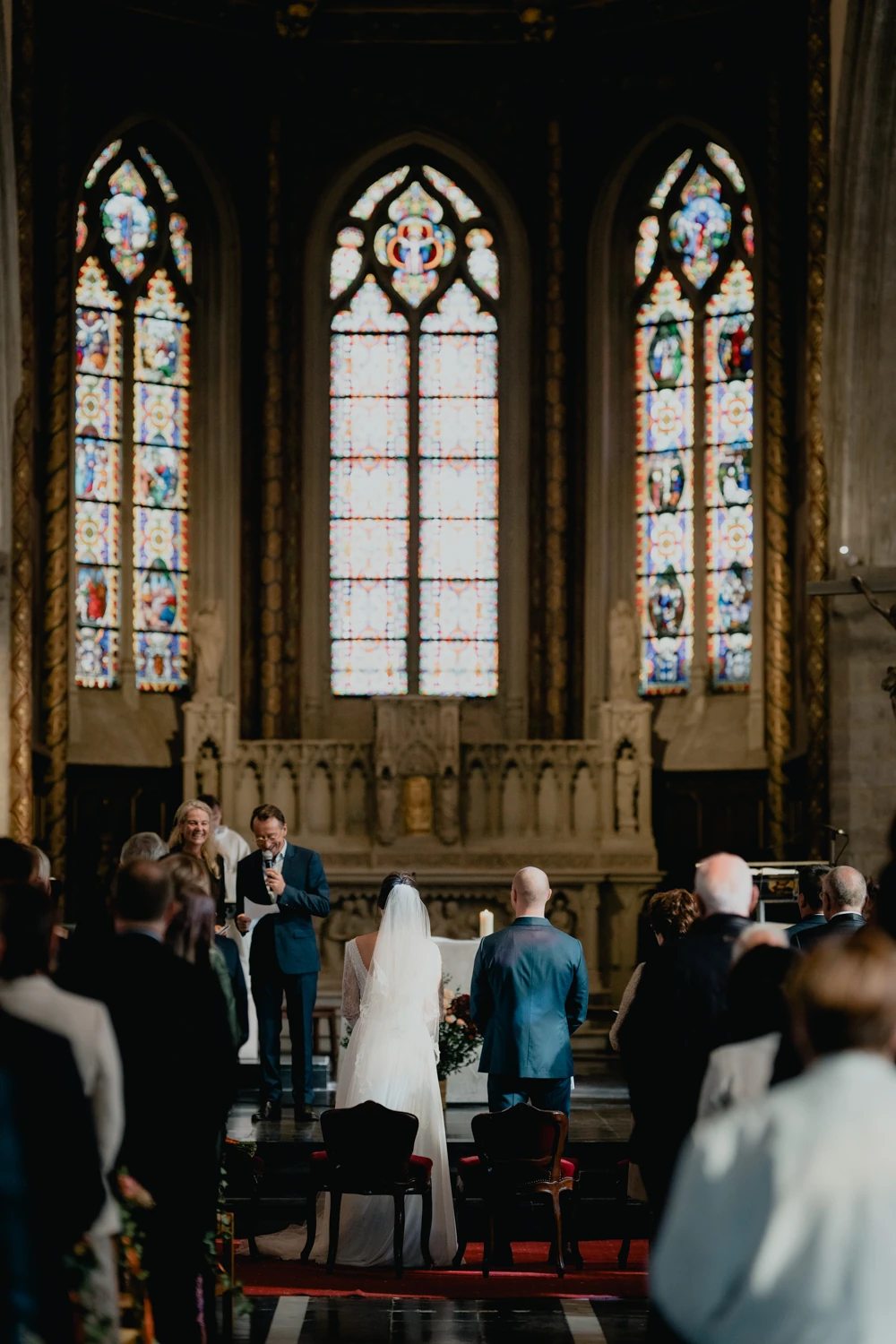 Les mariés devant les vitraux pendant la cérémonie à l’église.