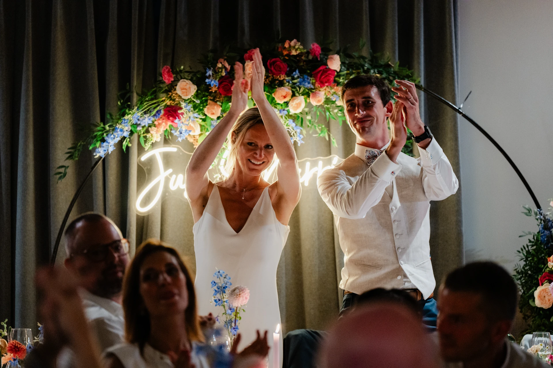 Les mariés célèbrent leur soirée sous une arche fleurie.