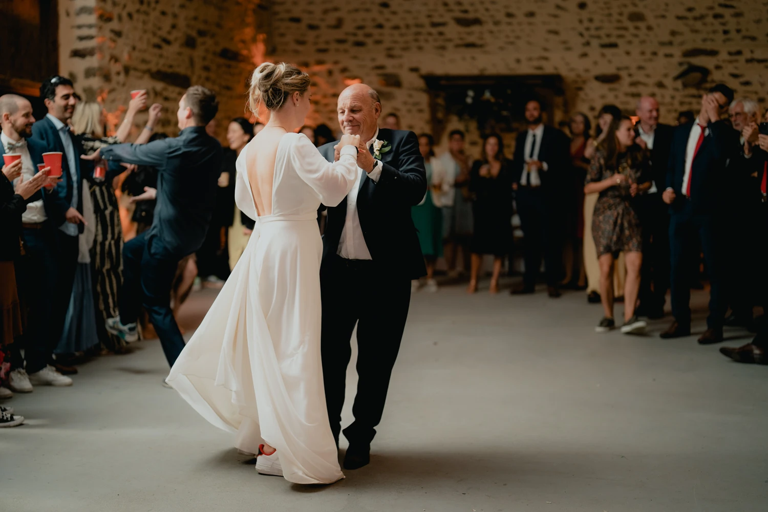 La mariée danse avec un proche pendant la réception.