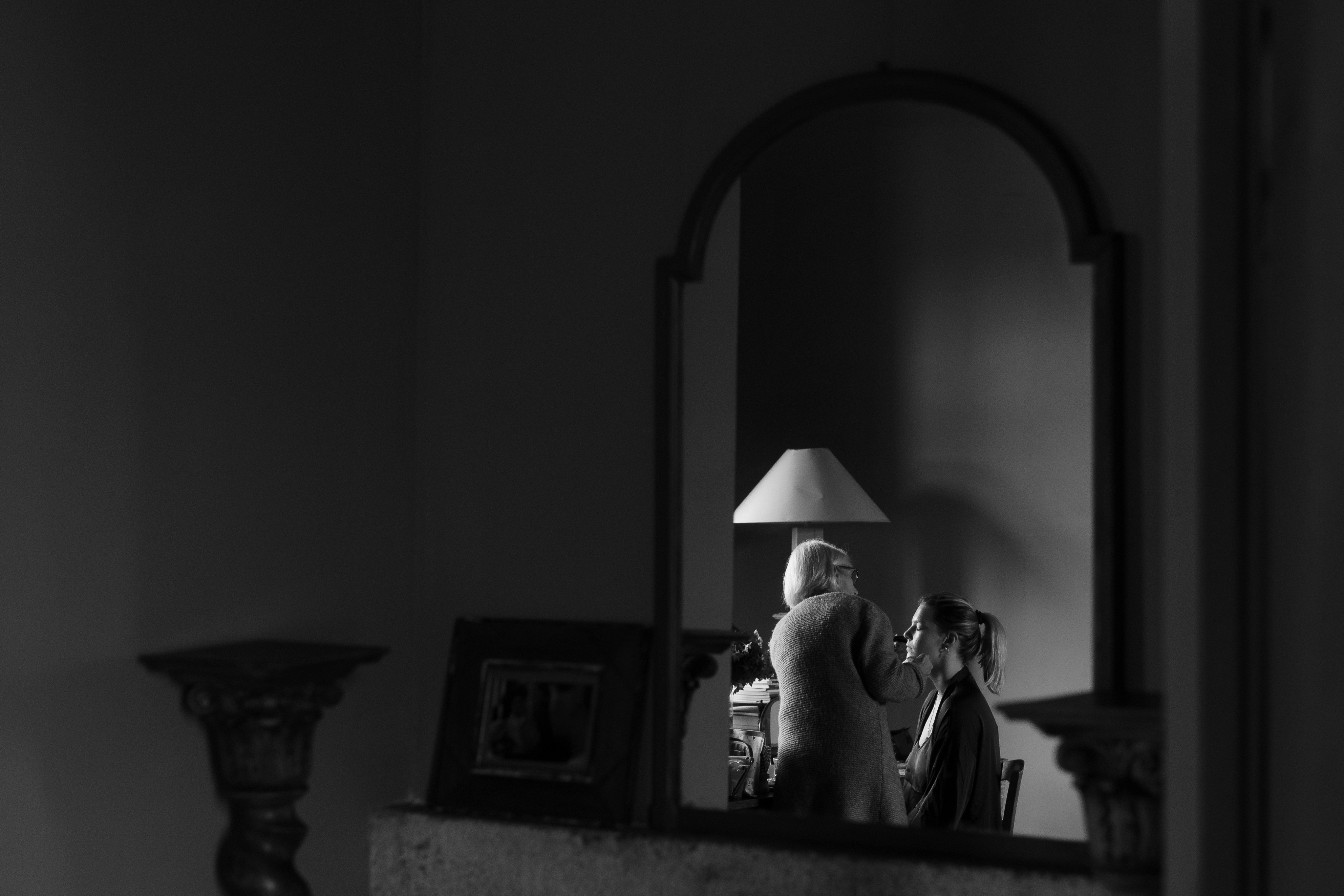 Les préparatifs de la mariée se reflètent dans un grand miroir, en noir et blanc.