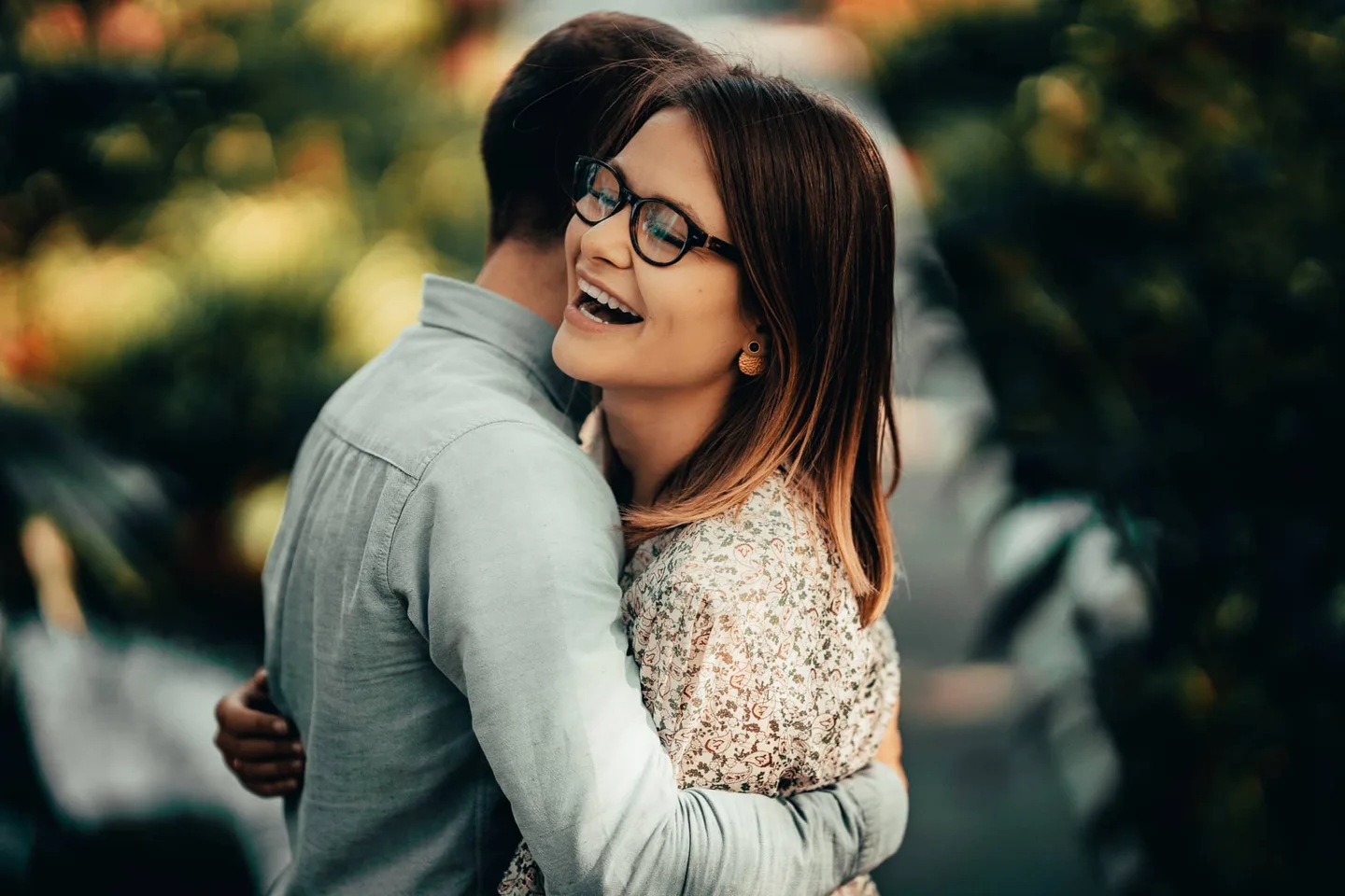 Un couple s’enlace dans un jardin.