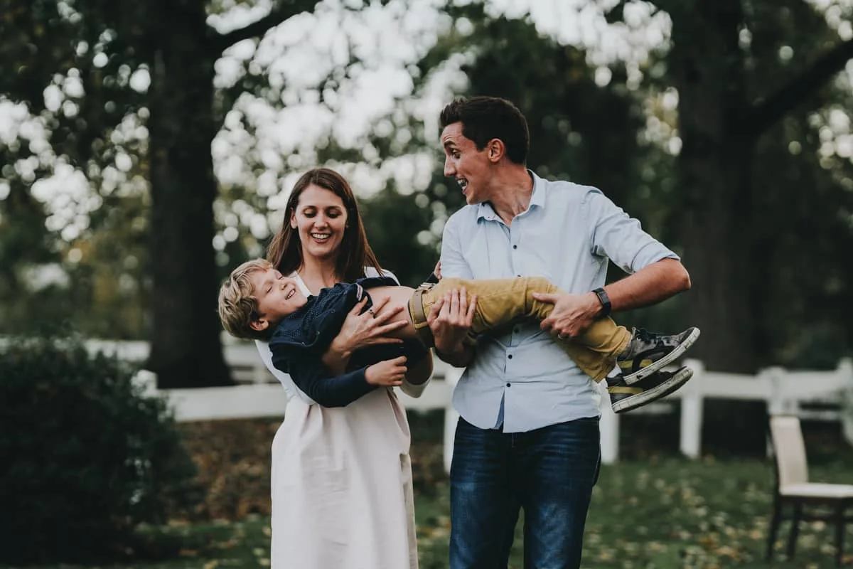 Des parents et leur bébé pendant une séance en extérieur.