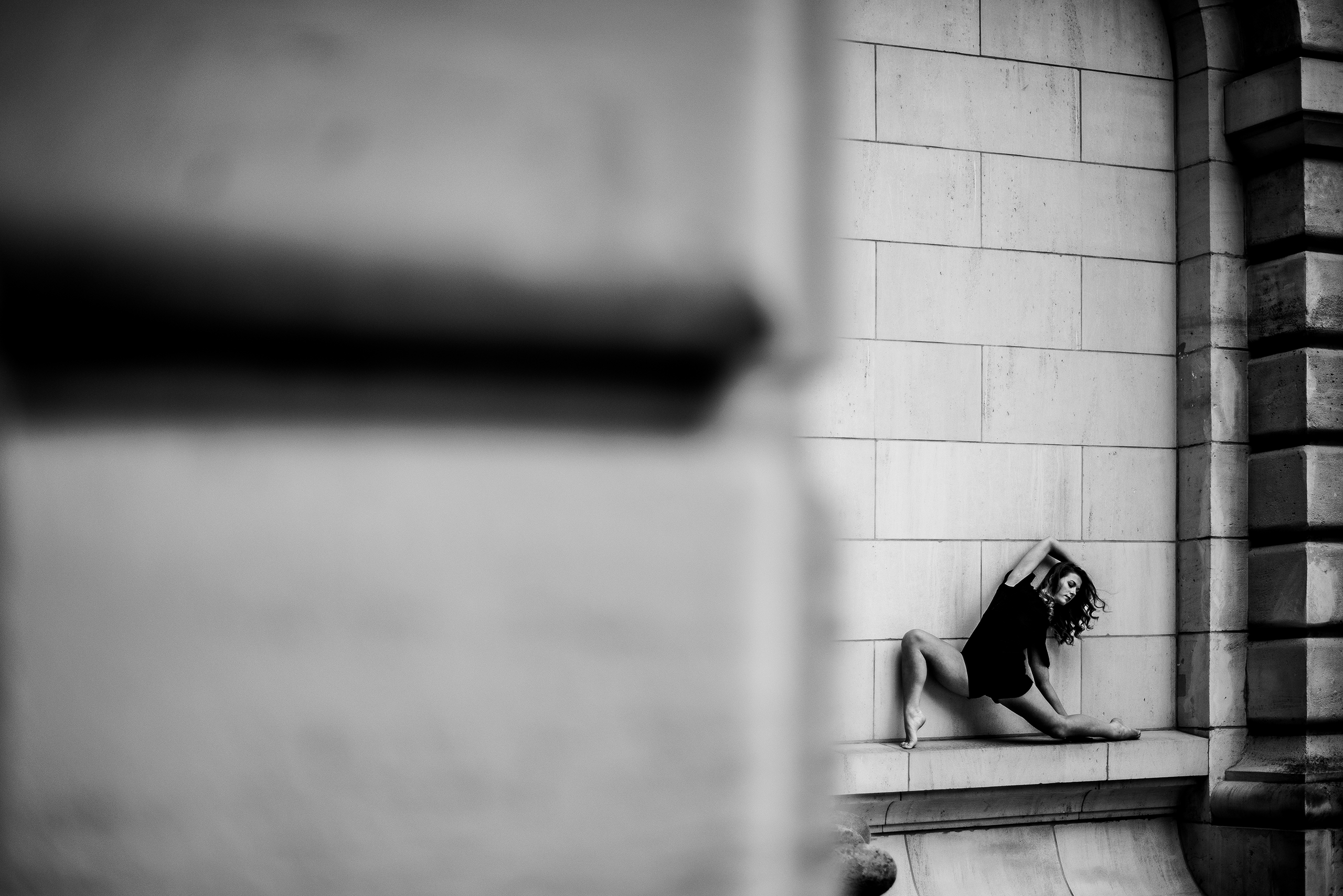 Danseuse photographiée en noir et blanc devant une façade de pierre à Lille.